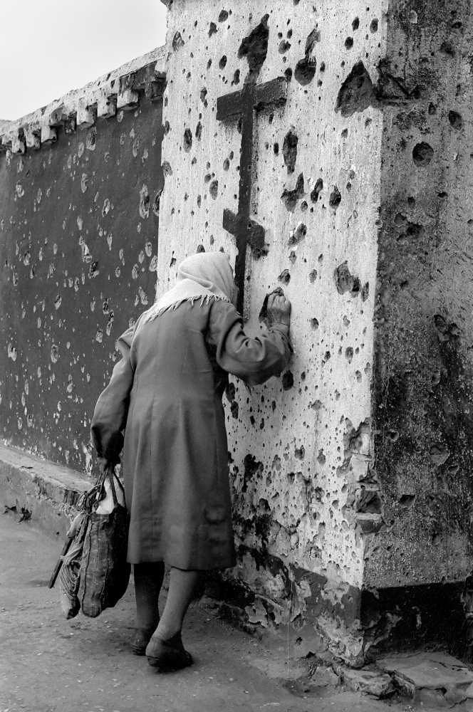 Forgotten Wars - A woman kisses the Russian Orthodox cross in front of a...