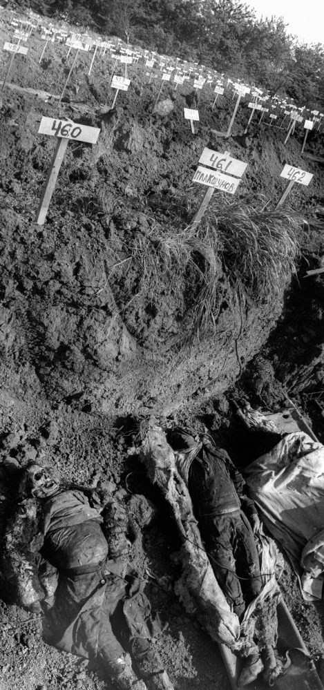 Forgotten Wars - Bodies are laid out at a mass grave on the outskirts of...