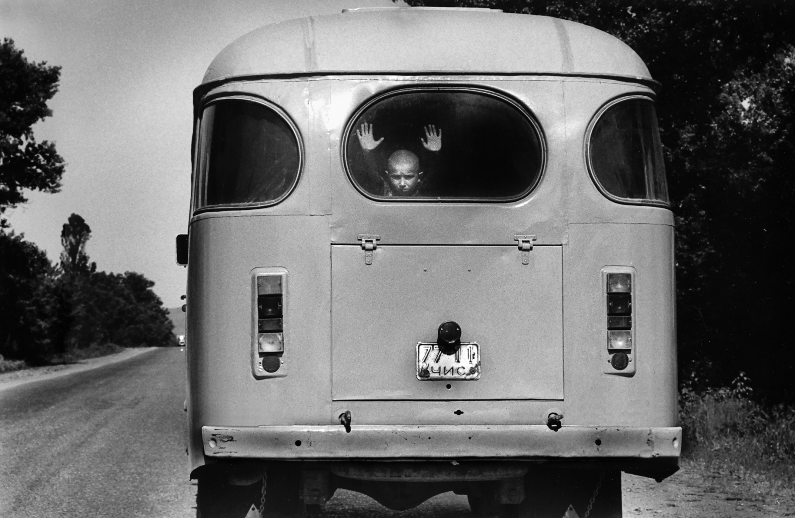 Forgotten Wars - A young boy peers out of a bus as he and other refugees...