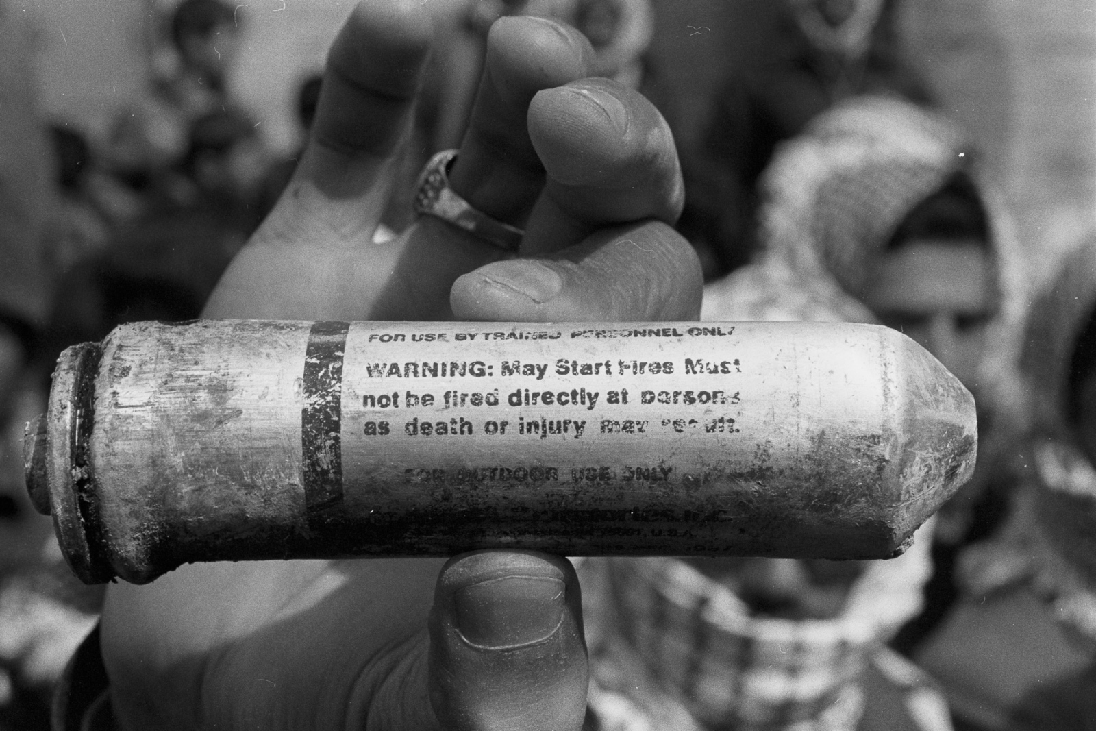 Forgotten Wars - A child holds up a tear gas canister that was fired at...