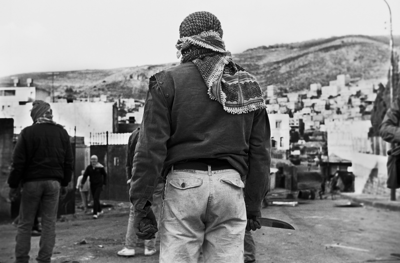 Forgotten Wars - With a knife and rocks in hand a Palestinian youth stands...