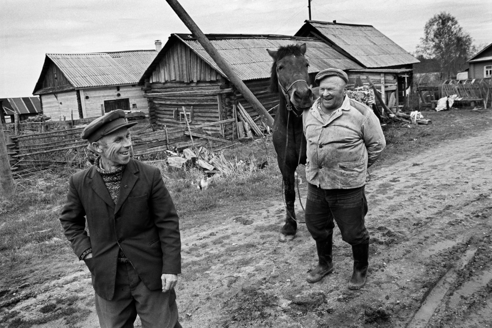 Alexei Gromov (left) and Vasili Semyonov chat on a dirt road in Anufrievo. Vasili is known as the first villager to leave the Communist Party.