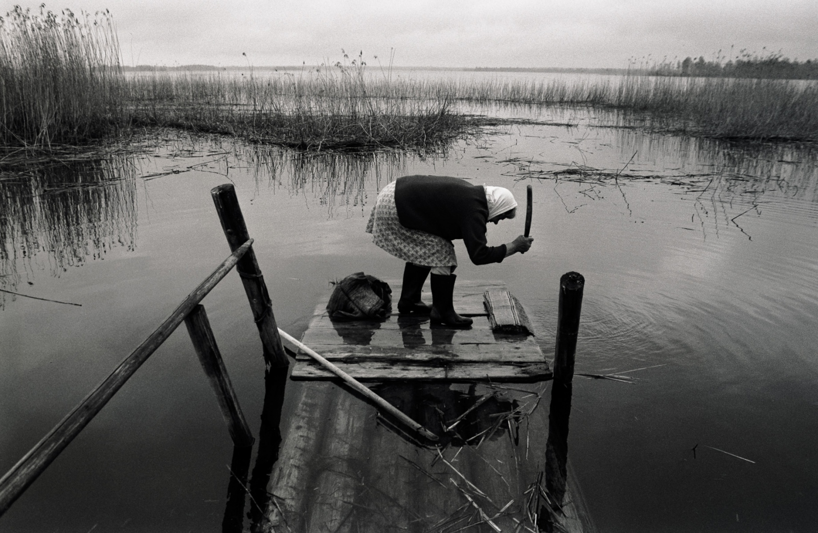 Russia - The Village of Anufrievo - Maria Vasilievna Ivanova washes her rug in the lake next...