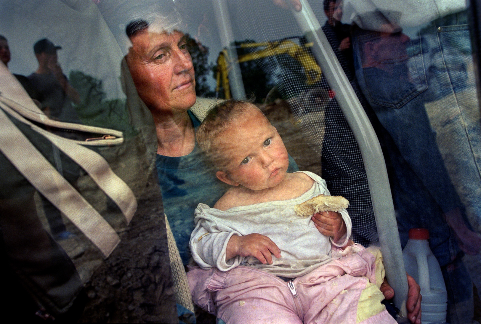 Home -  A mother and child wait to be bused to the Senokos...