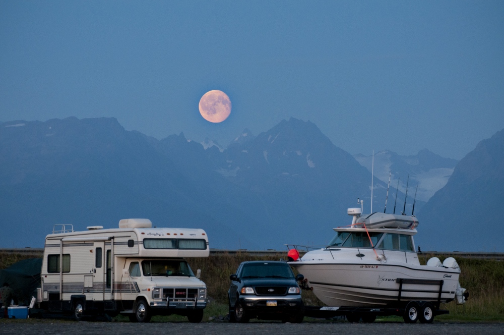 An almost full moon rises above...it in Homer, AK August 7, 2009.