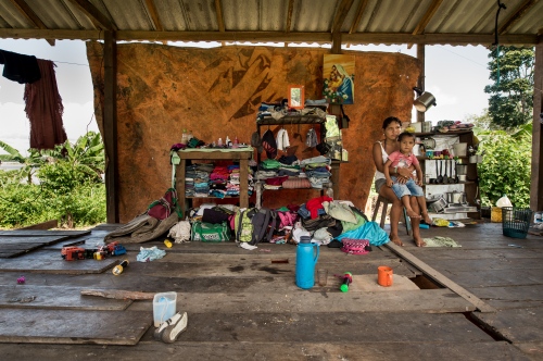 Image from Igaracu -                 A woman sits with her son in their home...