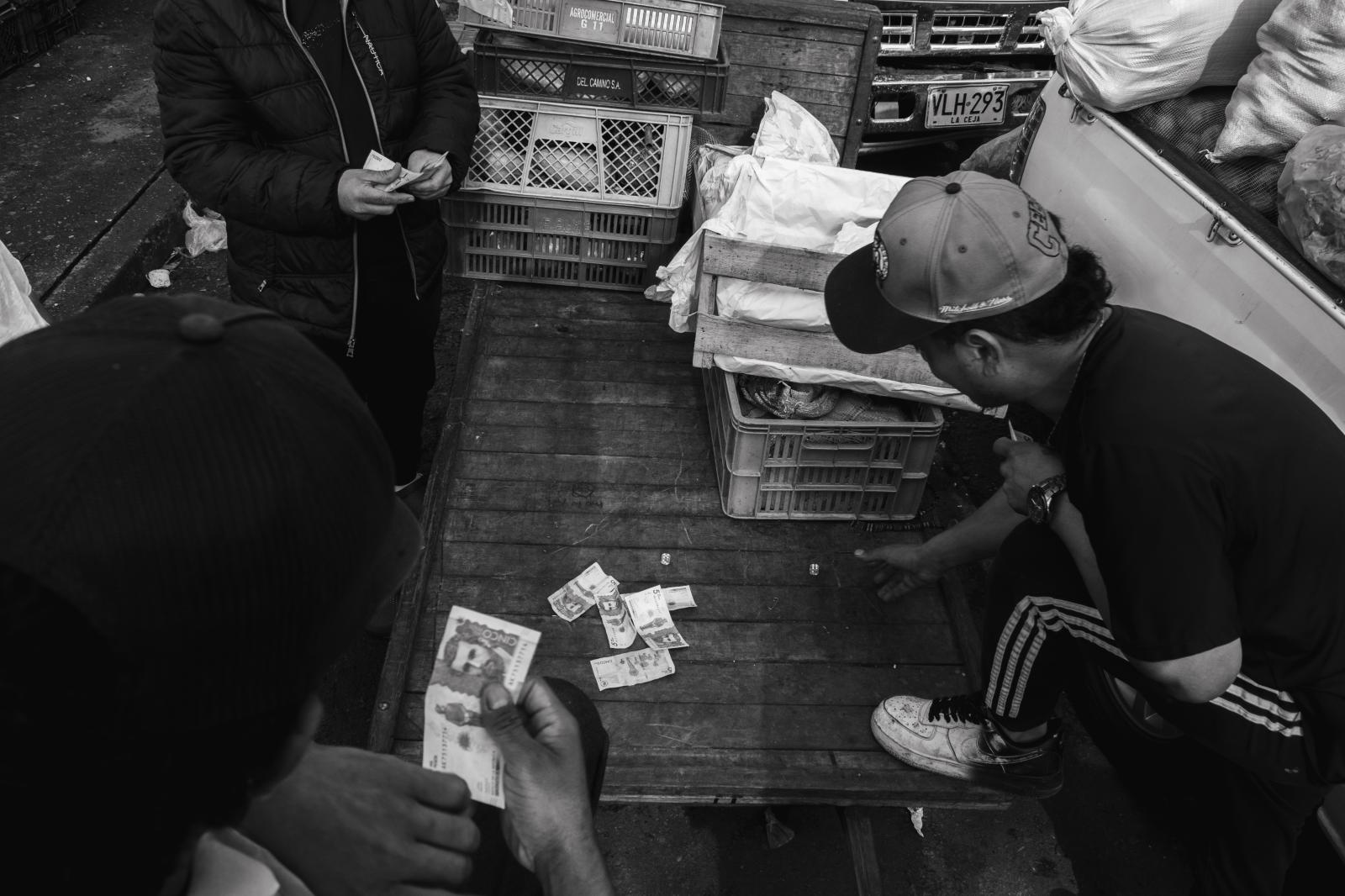 Carga: The Weight They Carry -  Gambling hard-earned wages on dice rolls, these young men grasp fleeting moments of escape from...