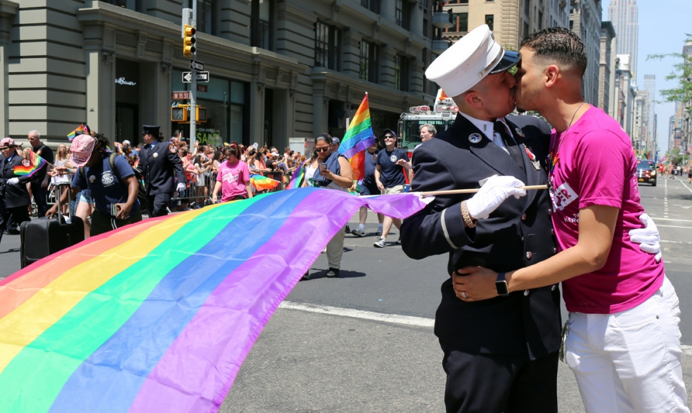   Dozens of floats and some 20,000 participants attend the Gay Pride parade, which starts at 36th Street before turning towards the West Village. The march comes at an emotional time, just weeks after a mass shooting at a gay club in Orlando, Fla. On Fifth Avenue, FDNY Lt. Victor Berrios kisses his fiancee Christopher Castro while marching in the parade.  