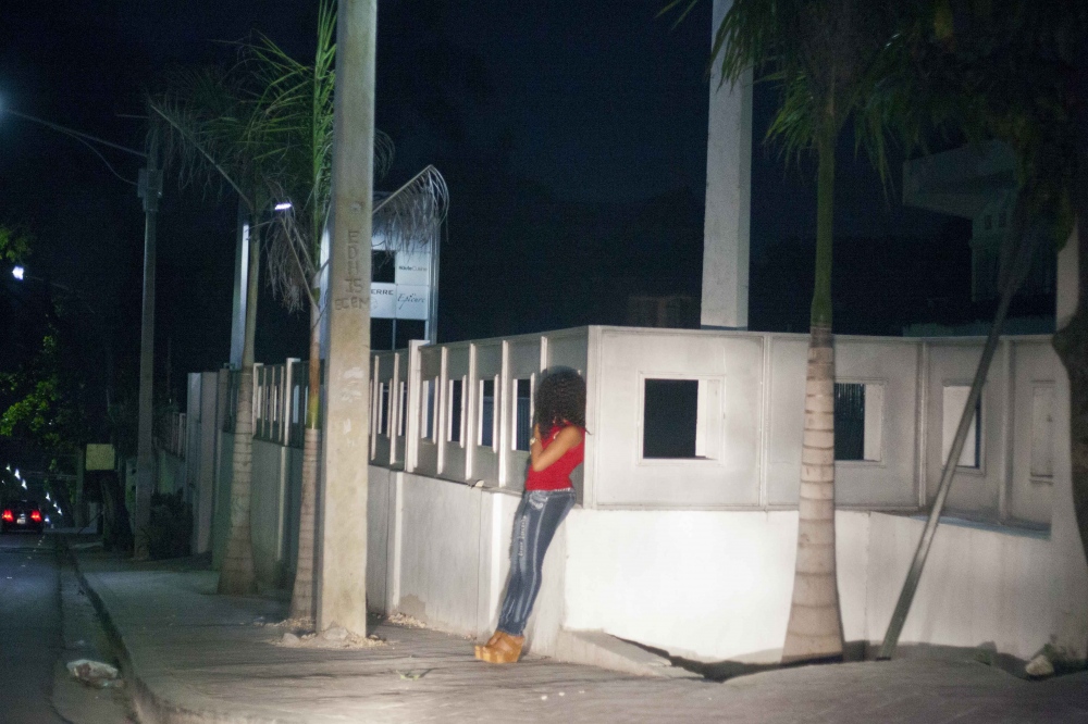   A sex worker waits for the arrival of guests in the streets of Petionville  