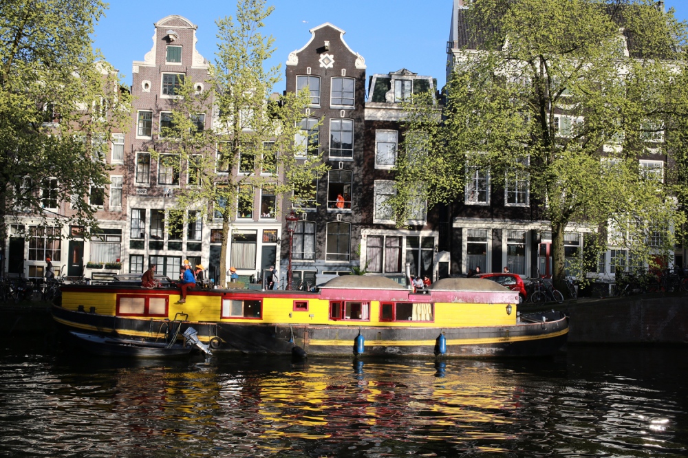  A young couple enjoy a glass of wine atop a house boat parked in one of the many channels around Amsterdam. 