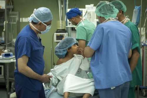   9 year old Fatma Othman in surgery awaiting anesthesia from the Al Shifa anaesthetists. Dr Abdul Hammad who will be undertaking the kidney transplant operation along with Colleague Sanjay Mehra hold Fatma&#39;s hand while she waits.  