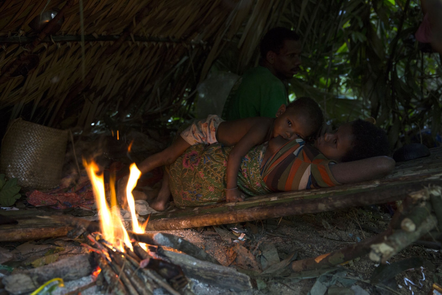 THE MANIQ - A child feeds from his mother inside their traditional...