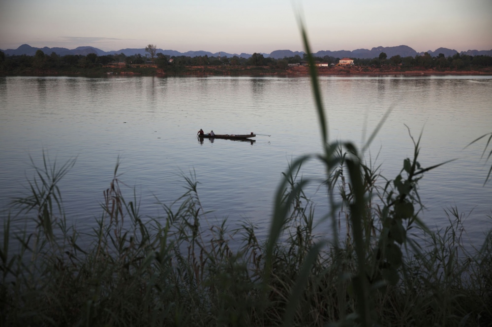 The River Mekong at dusk. Laos stands at the other side. Dogs are always shipped across the...