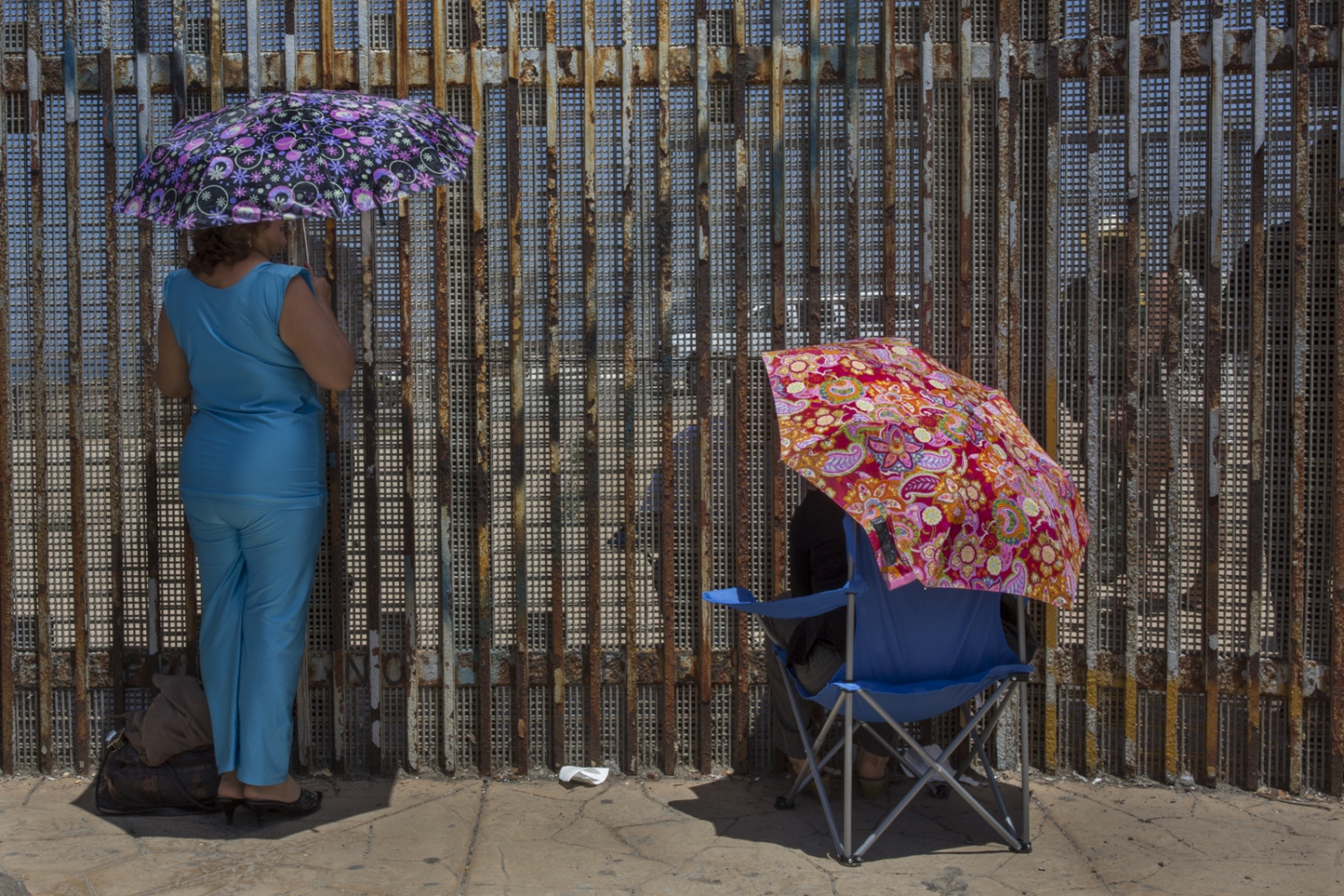  Two women meet with family members under the July sun at Friendship park, the only meeting place...