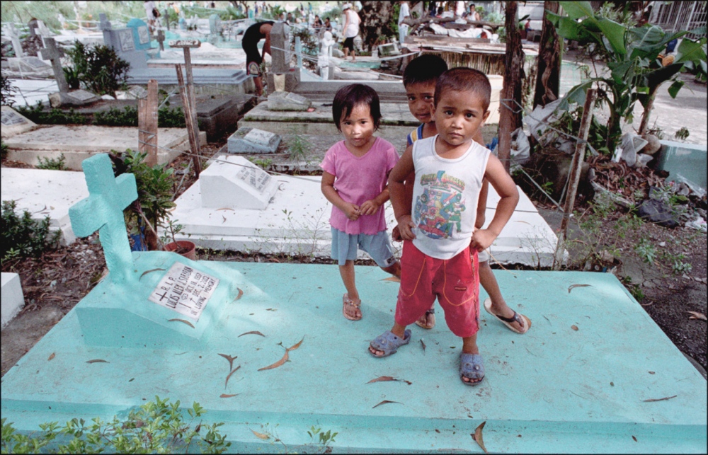 Three Children Standing on Grav...ila, Philippines, November 2005