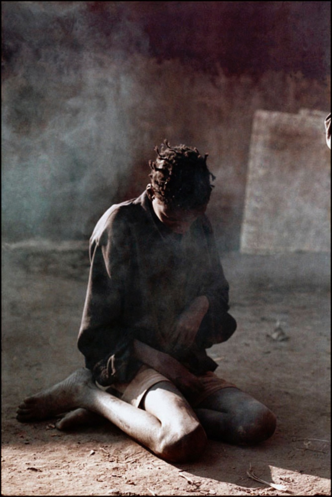 Angola's Civil War -  Girl Sitting, Surrounded by Smoke, Caala, Angola, July...