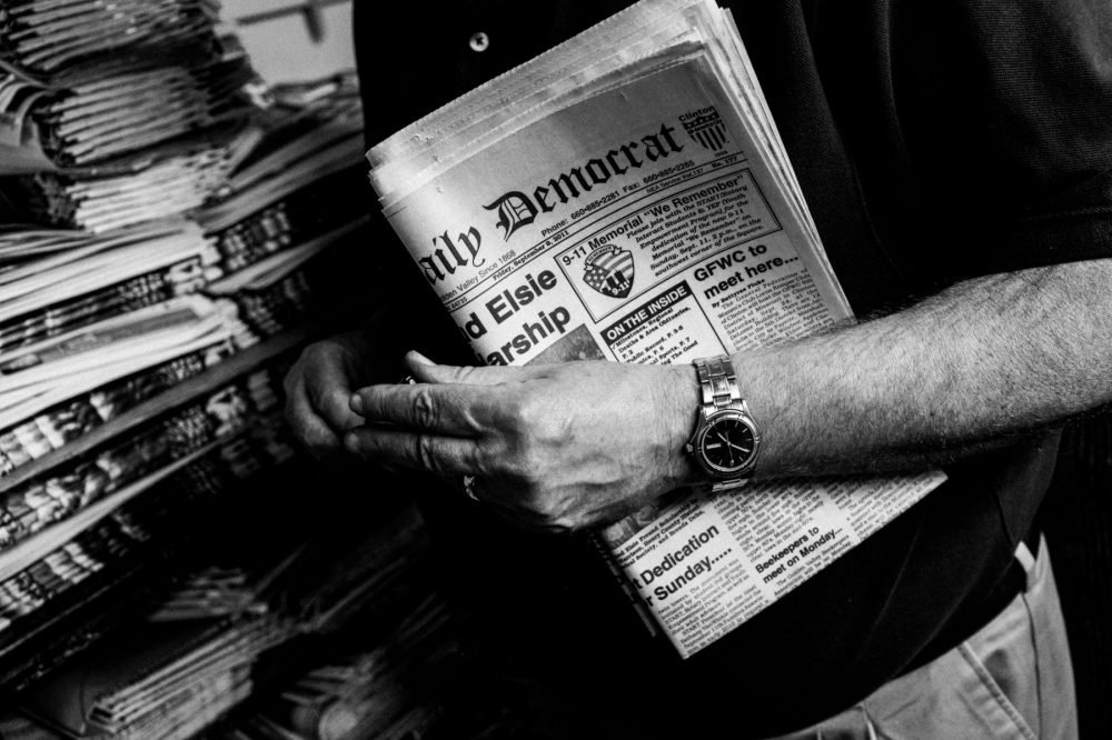 Dan Miles holds a copy of the Clinton Daily Democrat.