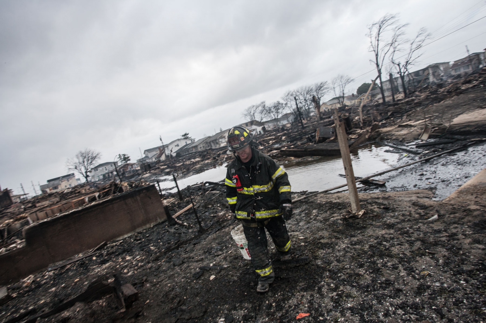 The Rockaways After Hurricane Sandy - Firemen walks through the fire devastated area in Breezy...