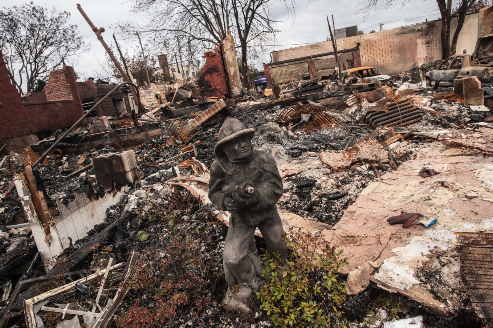 The Rockaways After Hurricane Sandy - A fireman's statue in front of one of the destroyed homes...
