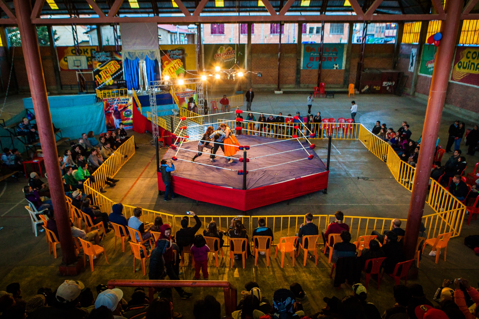  A team of cholitas wrestle in El Alto’s sports complex. In July 2014, a group of cholitas decided to form their own wrestling association and organize their own events—despite Bolivian mainstream culture’s tendency to enforce a rigid understanding of traditional gender roles. Many of these women have found that their male romantic partners were threatened by female strength; but that doesn’t stop these women from doing what they love. 
