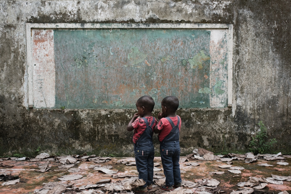 Two twins stand in front of wha...Bellavista, BojayaÌ, Colombia.