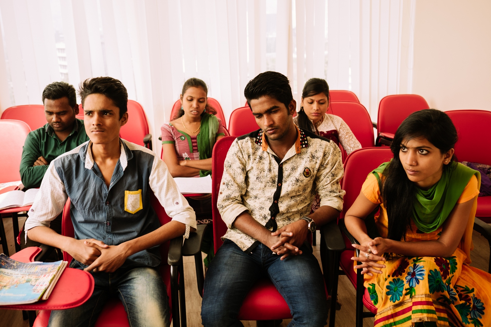 How Can I help You? - Young Indian agents in a training room listening to their...