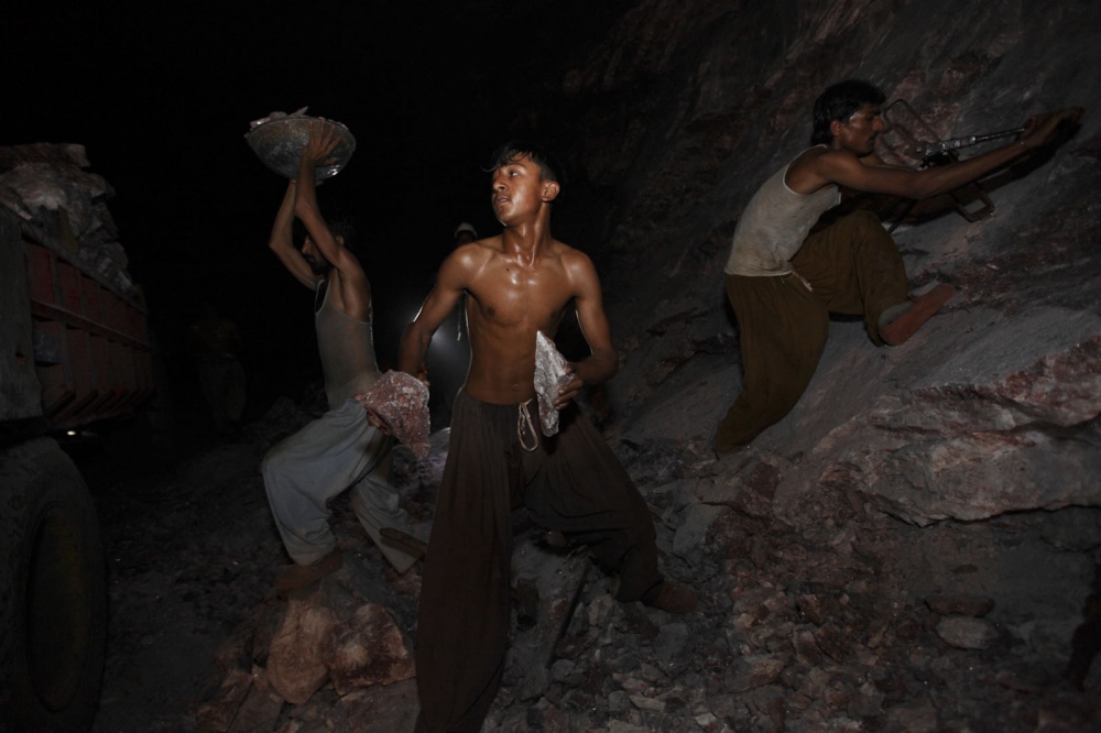  Salt workers toil in pitch darkness inside the Khewra salt mine. Once the salt is blown from the...