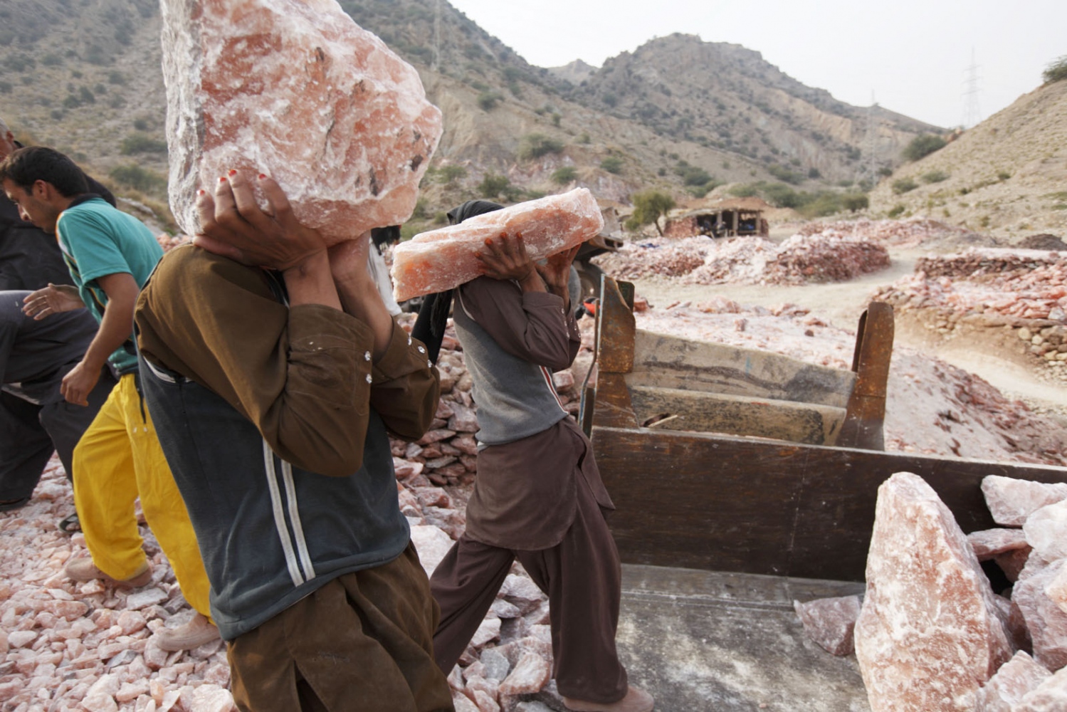 PAKISTAN'S SALT MINES - Men loads up a trailer with large pieces of pink rock...