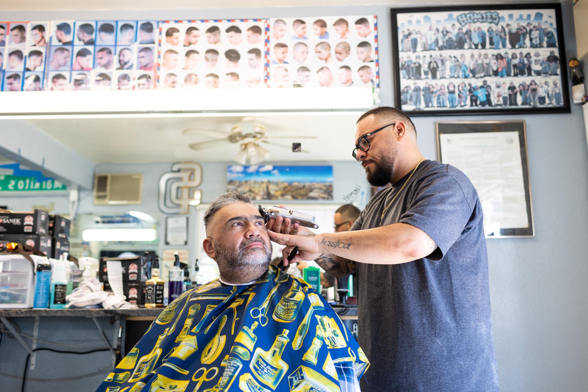 Robert Wood Johnson Foundation - Barber Jhonny Chingas gives Pablo Molina a haircut at...
