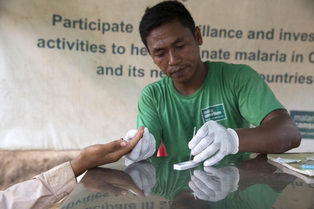 Image from NGO/DEVELOPMENT - Mobile Malaria Worker Chuun Thy treats a patient at his...