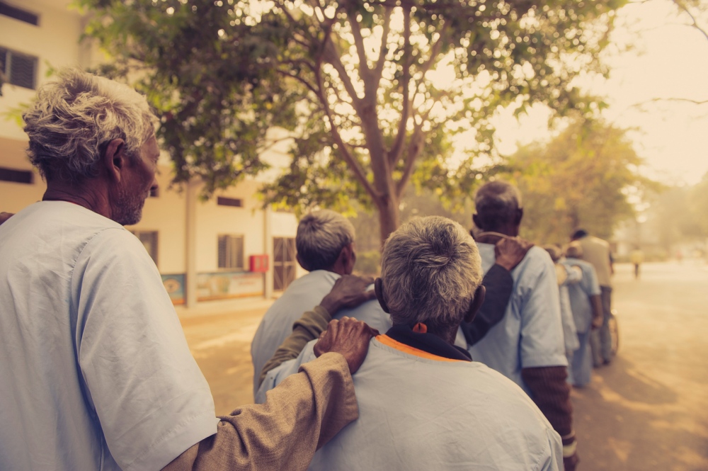 Men hold shoulders for guidance as they walk towards the operating theatre in Chitrakoot, India.