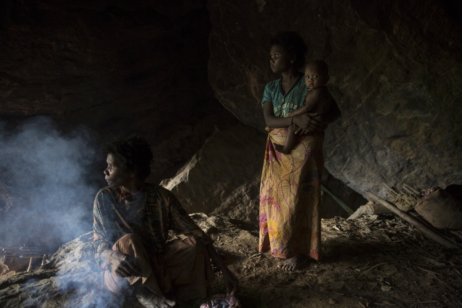 THE MANIQ - A mother and child stand in a cave. During the rainy...