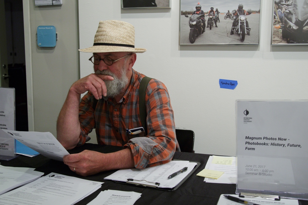 June 21, 2017 - International Center of Photography School. New York City, NY, USA - Larry Towell sitting at the welcoming desk at the "Magnum Photos Now- Photobooks: History, Future, Form" event.Â 