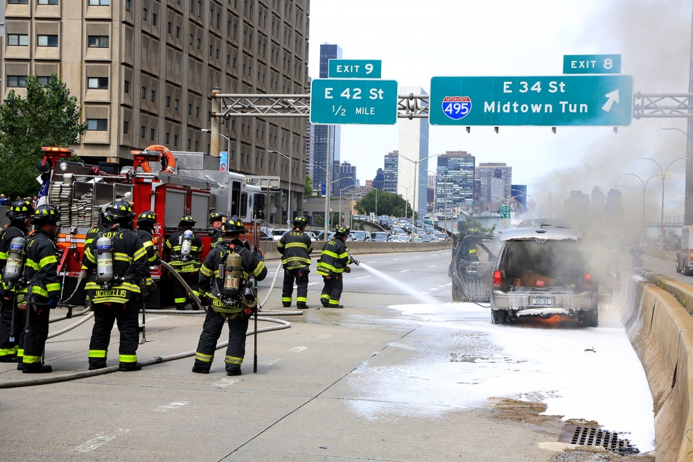   Firefighters extinguish a fire on a car at FDR Drive near East 34th Street in Manhattan.  