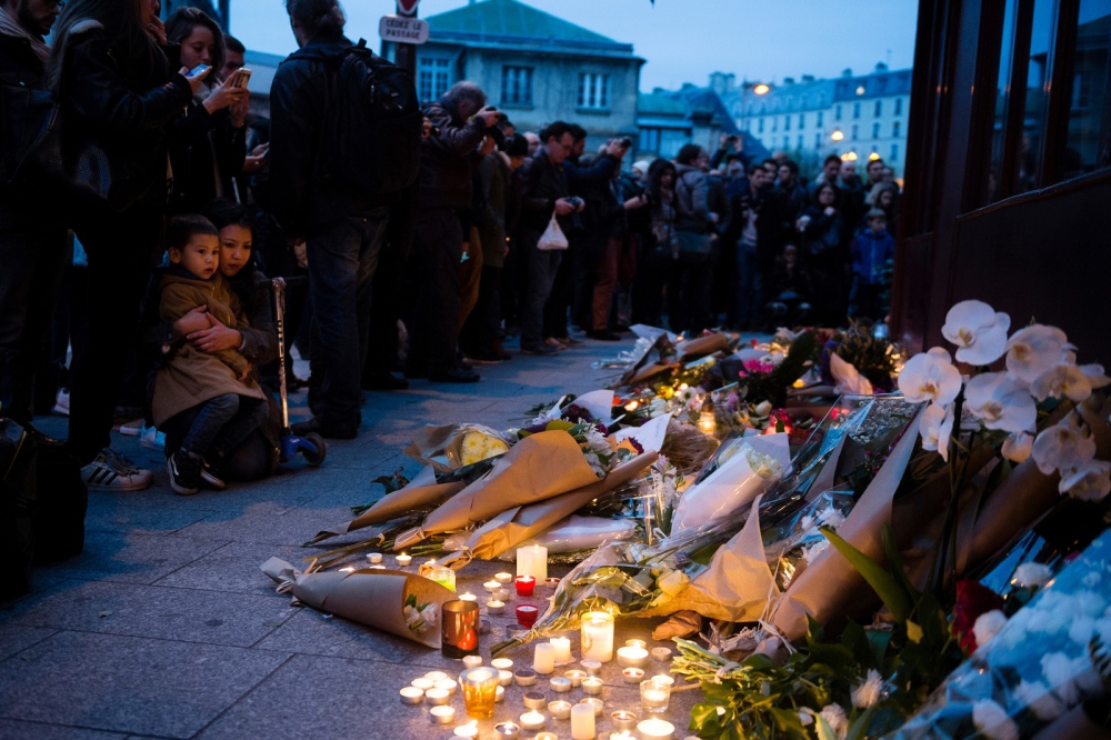 Flowers and candles outside res...undred people in Paris, France.