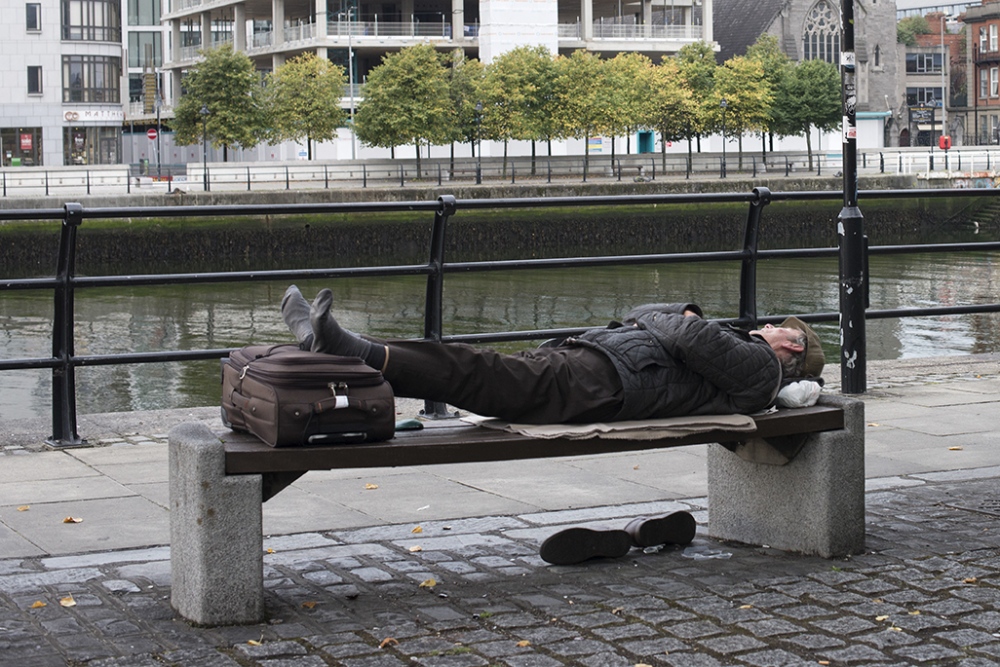 A man is sleeping near the Liffey River, Dublin