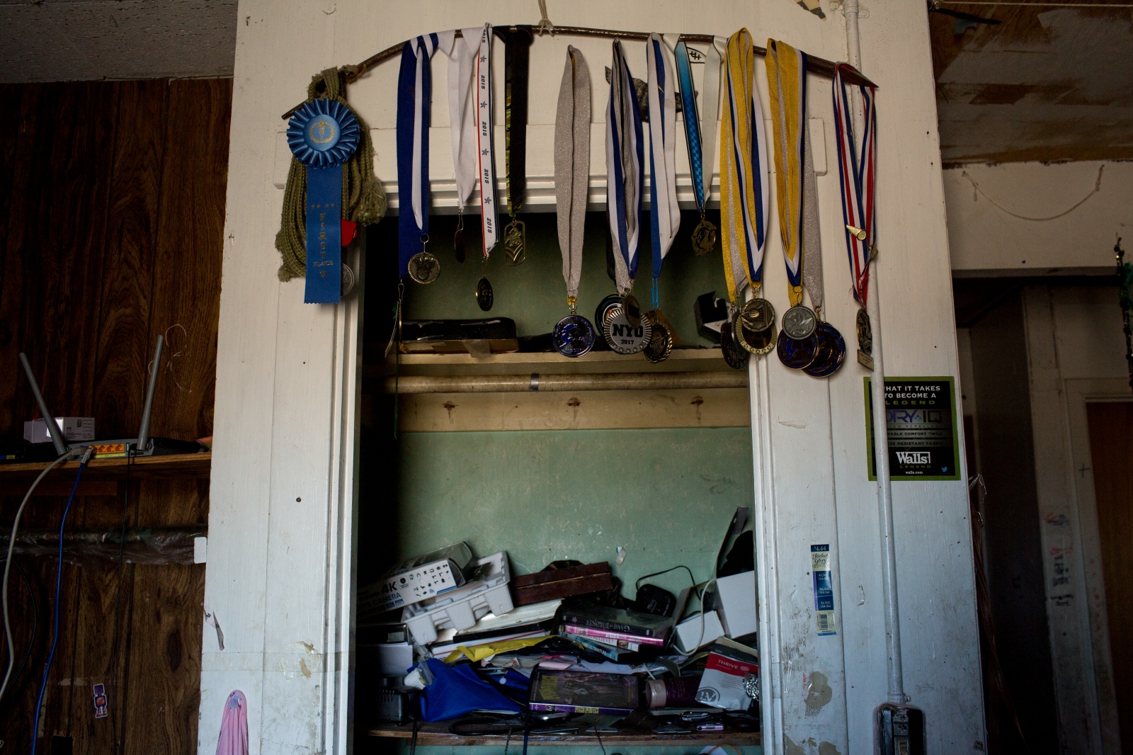 Athletic medals, mostly Chris Apassingok's sister Danielle's, hang from a harpoon...