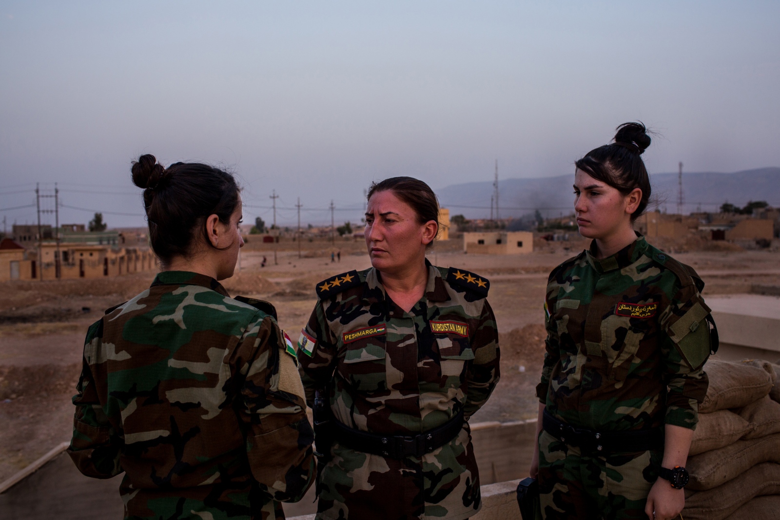 Captain Khatoon Khider, center, speaks to the women in her battalion as they fortify their base...