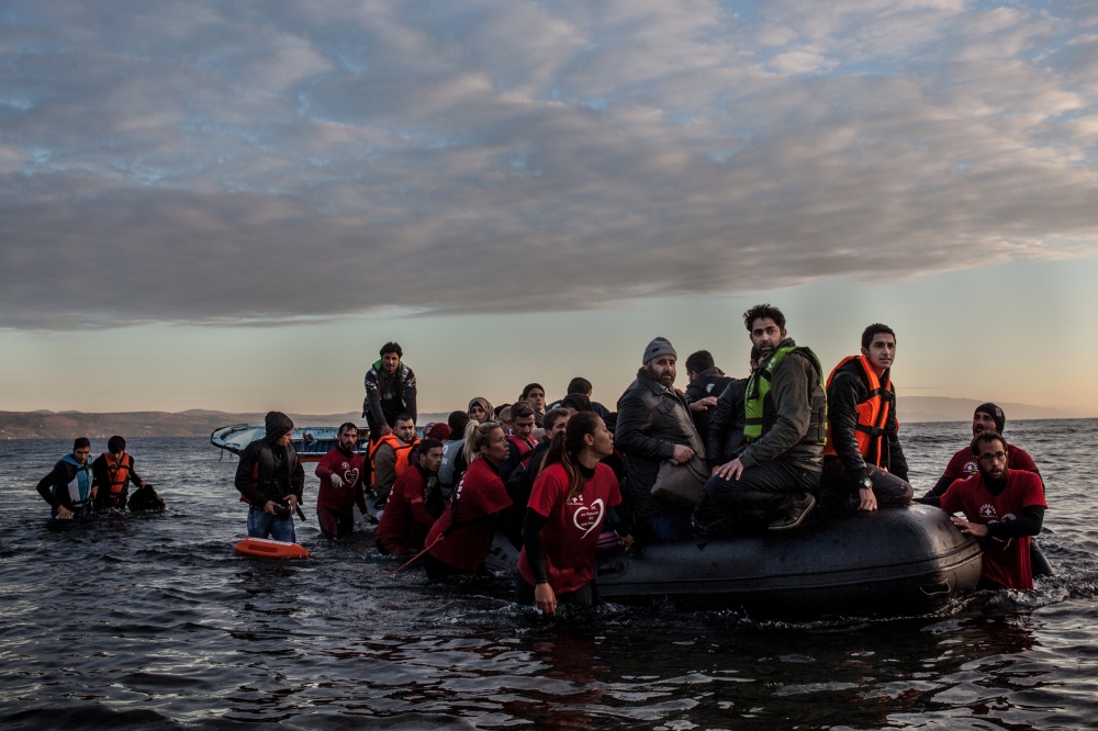 A boat filled with refugees and...om Turkey on December 4, 2015. 