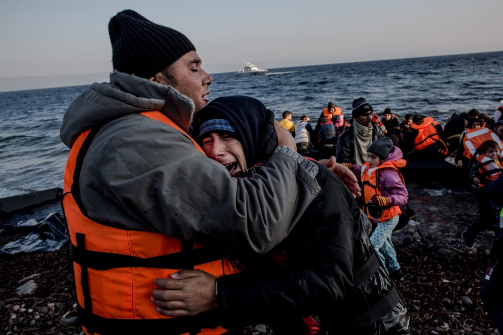 A man comforts his crying son s...for refugees fleeing conflict. 