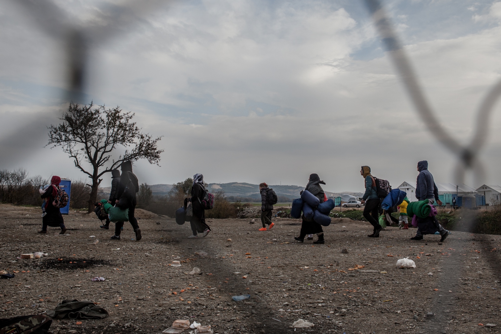 Refugees and migrants wait to cross the border between Greece and the Former Yugoslav Republic of...