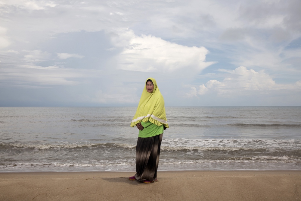 PORTRAITS - Rokeeyoh Sana-Ae stands on the beach located next to her...