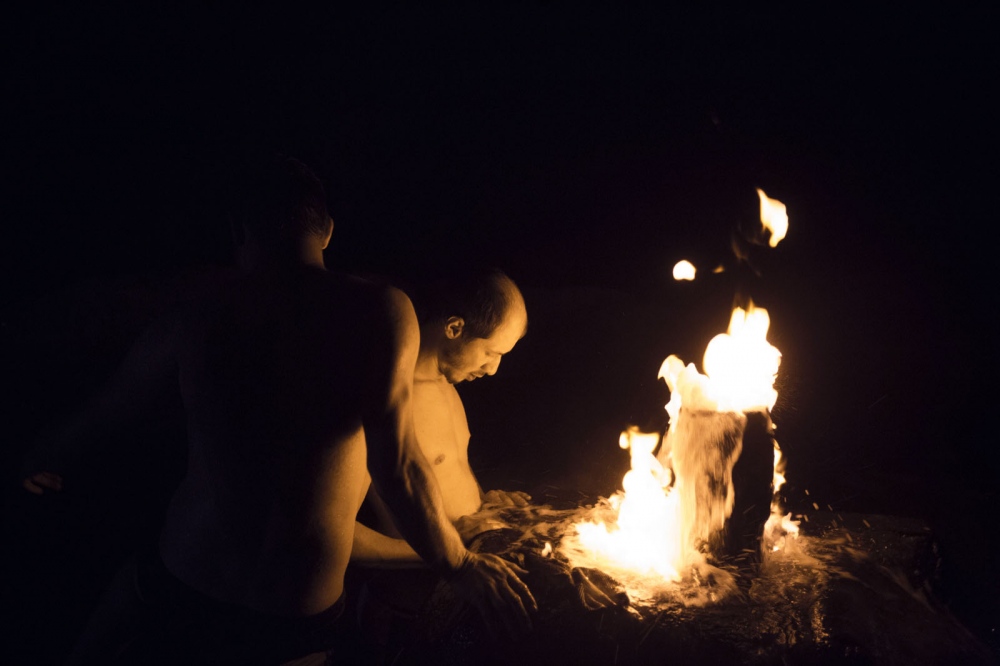 After a party, young Dagestani men visit a hot springs in the middle of no-where which has a flammable fountain of water.  Dagestan, Russia