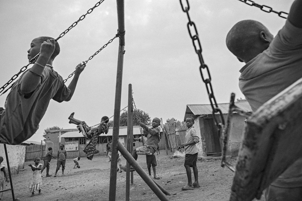 Children play on a swing set in...ng in the east of the country. 