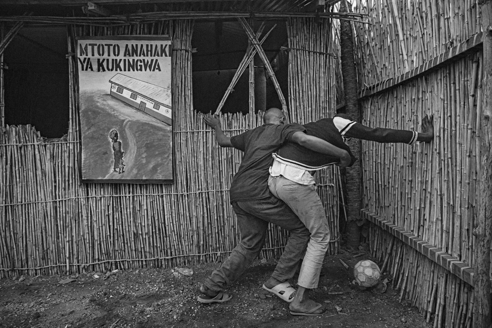 Former child soldiers Mumbere, left, and Habyarimana, play football in the courtyard of...
