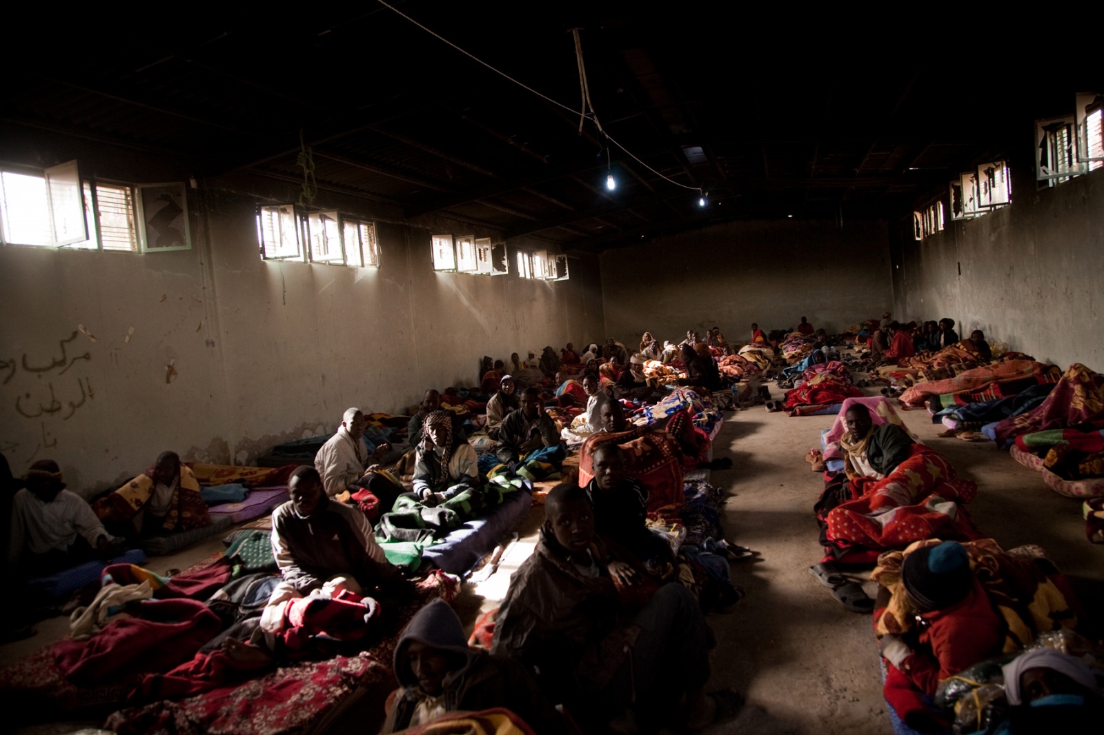 African migrants, at another temporary facility in Adjabiya on March 9, 2012 after being moved...