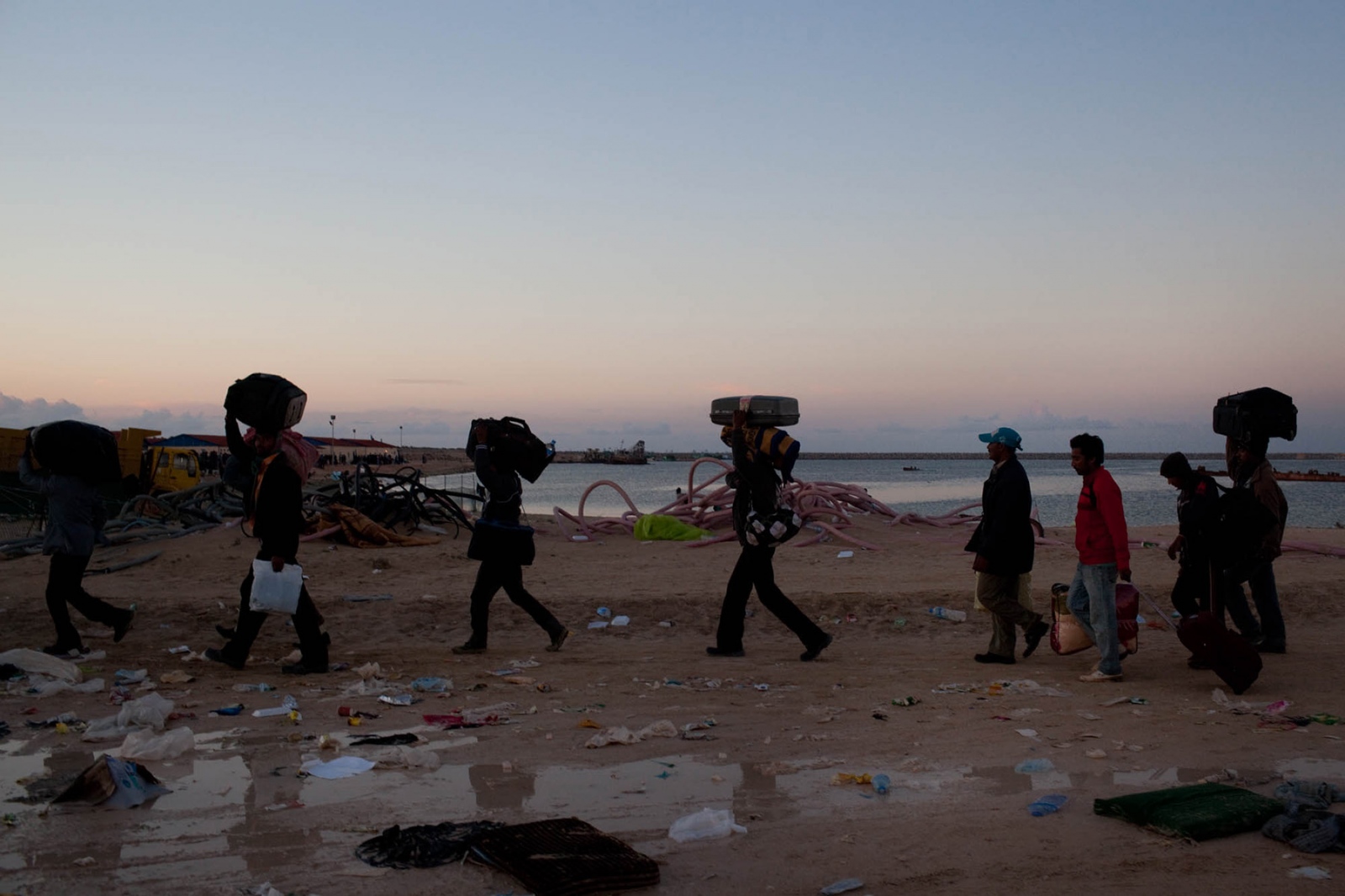 Libya: Migration Crisis - Bangladeshi migrant workers carry their belongings...