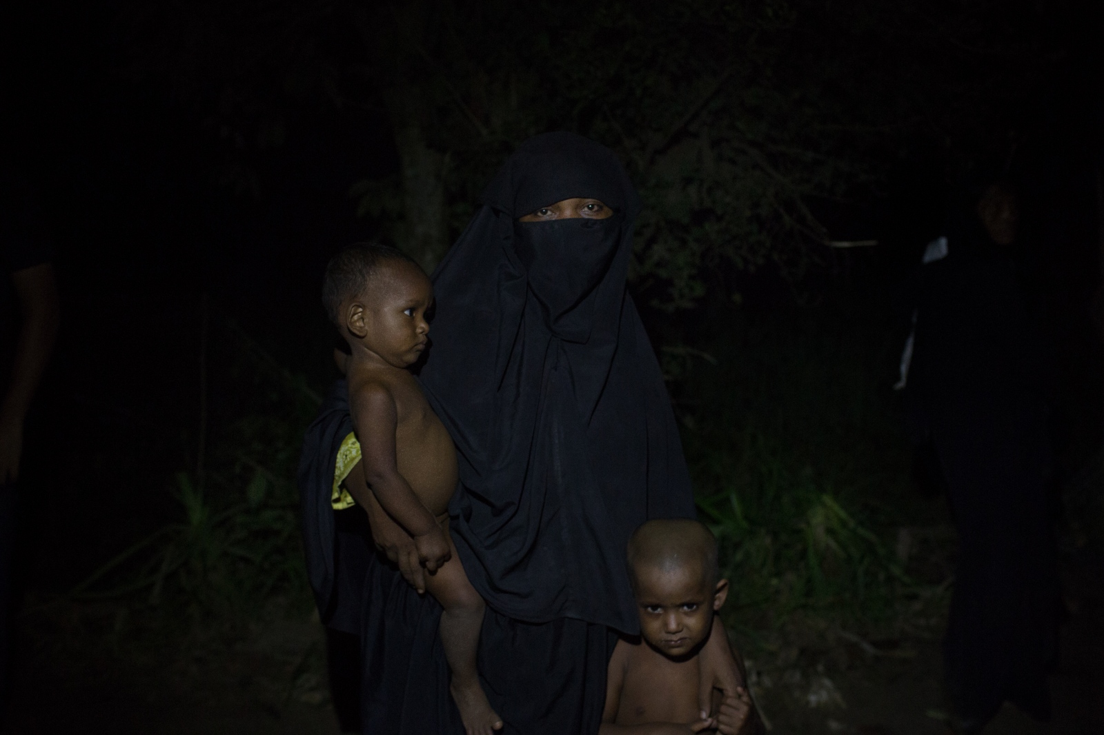  Nokayda, 21, waits with her two children by the side of the road for food and cash distributions...