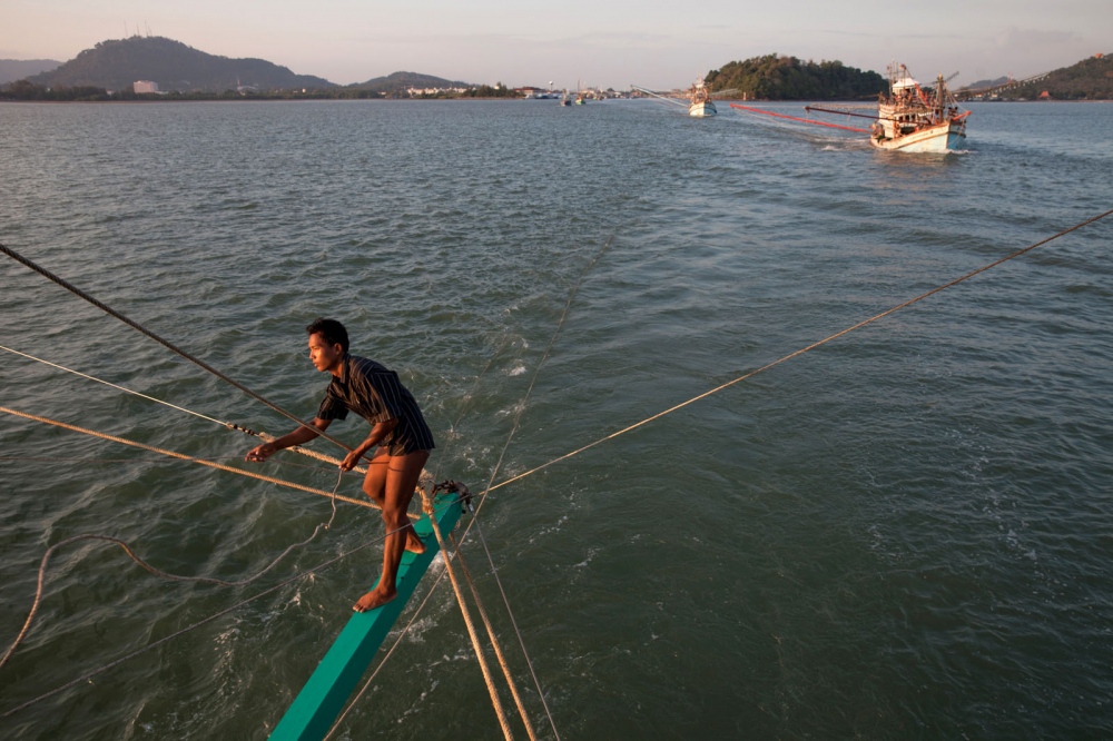 Thai fishing trawler boats leave for the ocean in the late afternoon and will return the...