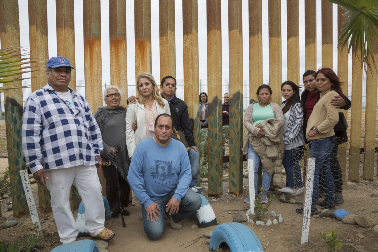 The Salgado family poses for a portrait. On the other side of the border fence (in the U.S.)...